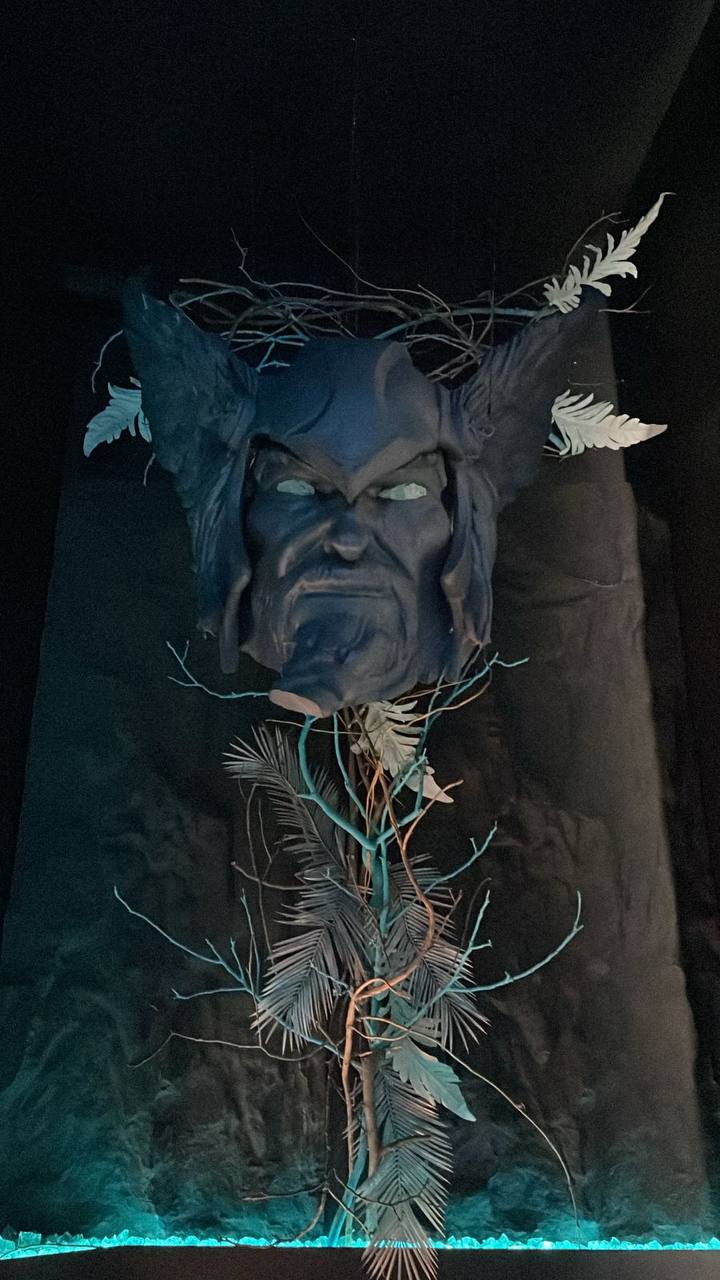 Большая 3D-голова и декоративные ветви в интерьере